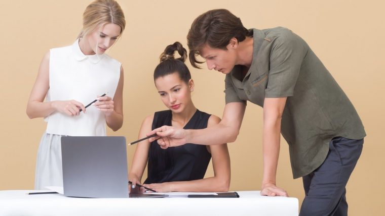 Dwie kobiety i mężczyzna nad laptopem - najlepsze strony Business English