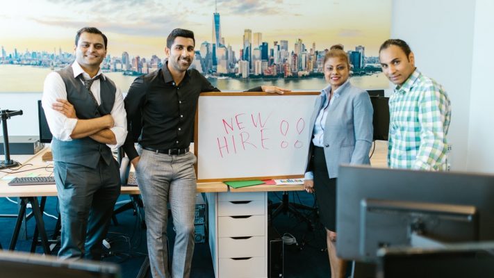Ludzie z napisem "new hire" na tablicy
