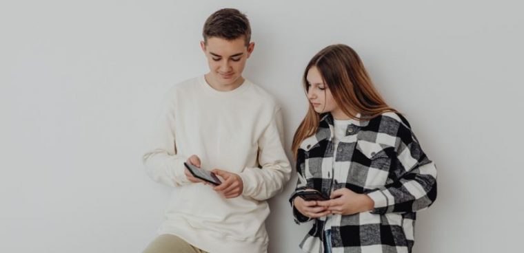 dwójka nastolatków porównuje na telefonach swoje aplikacje do nauki angielskiego