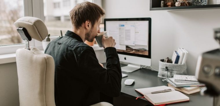 stopniowanie przymiotników angielski: młody mężczyzna siedzi przed komputerem