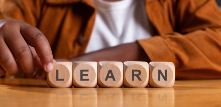 Napis LEARN ułożony z drewnianych kostek